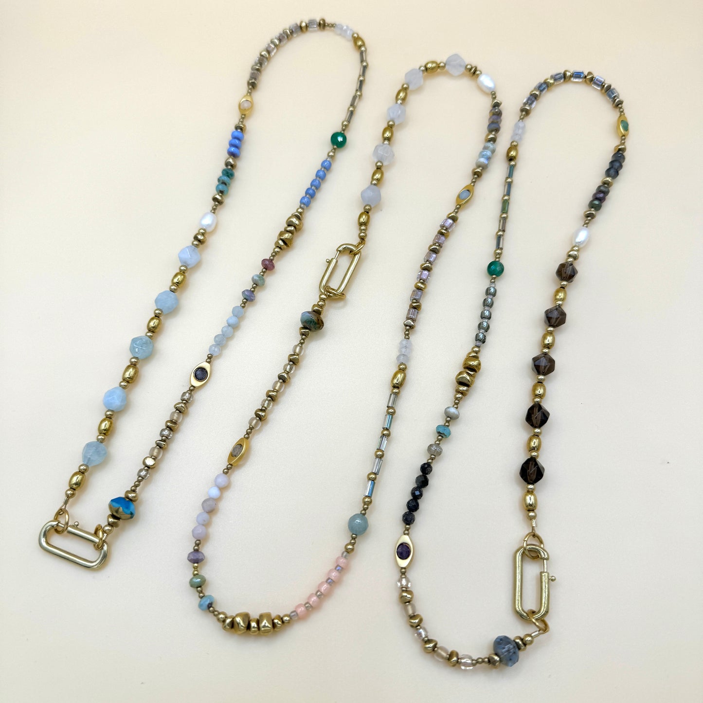 Collection of handmade boho beaded necklaces featuring delicate gemstones, gold accents, and layered minimalist styles by May & Moon