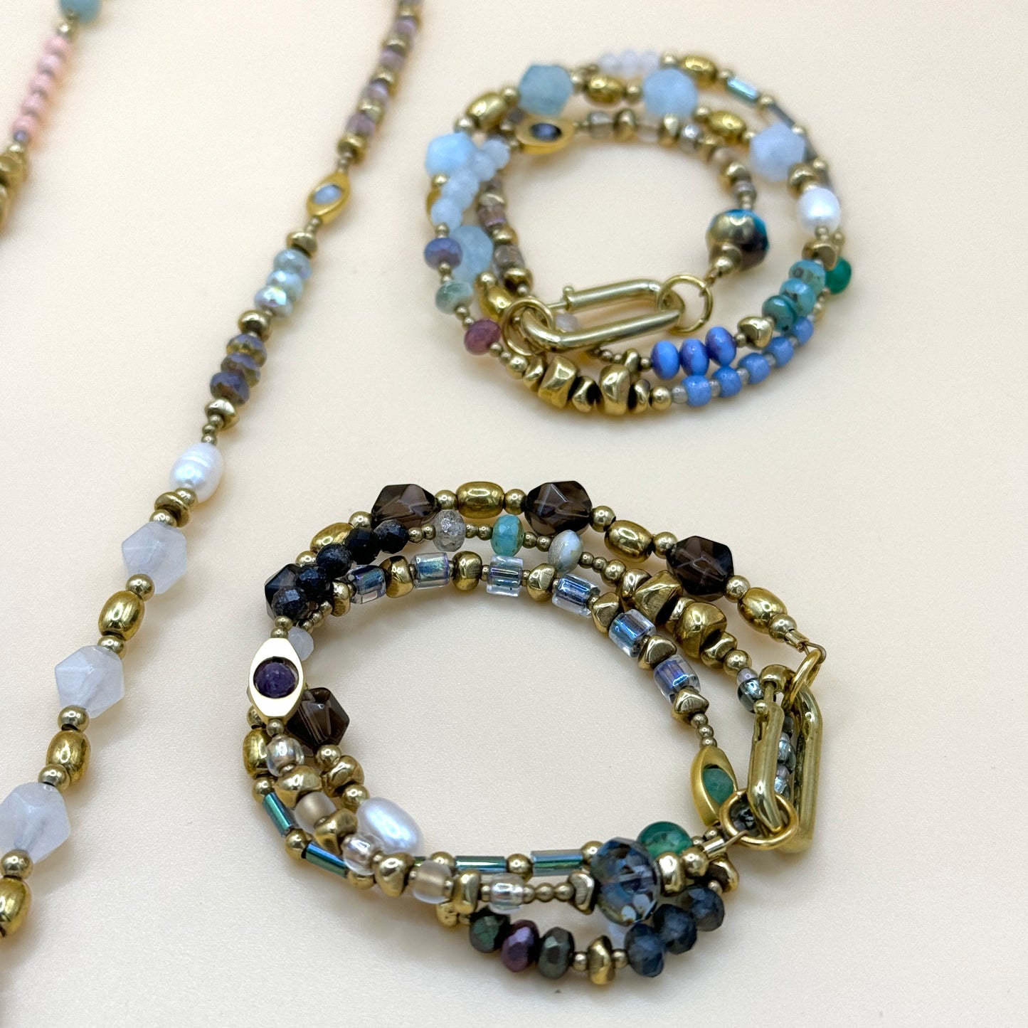 Handcrafted layered boho pastel and smoky beaded necklaces featuring natural gemstones, gold details, and artisan minimalist style by May & Moon
