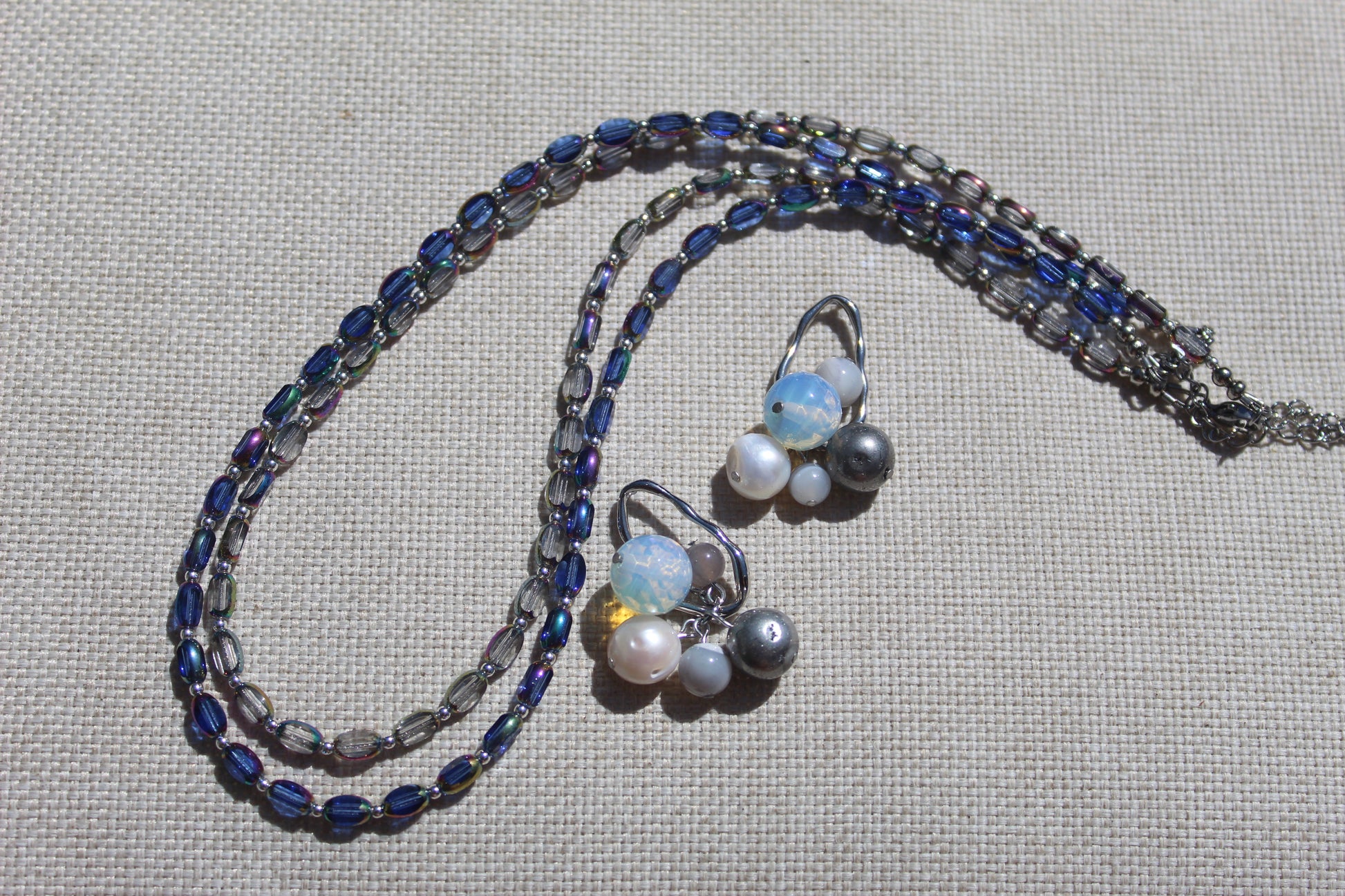 Baltic Bauble Earrings and matching Czech glass beaded necklace styled on linen with hematite, agate, pearl, and opalite stones
