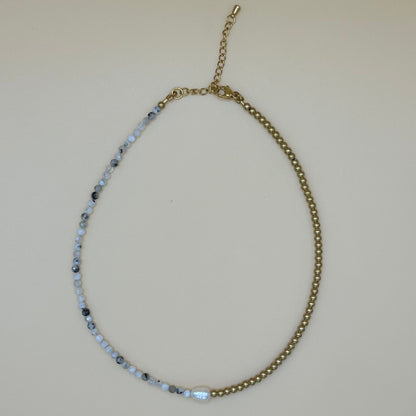 Flatlay of dainty pearl and gemstone choker necklace with adjustable gold clasp and natural beaded detailing on neutral background