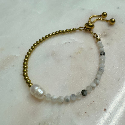 Lennon Bracelet by May & Moon shown on marble — handmade adjustable bracelet with freshwater pearl, brass beads, and speckled gemstones.